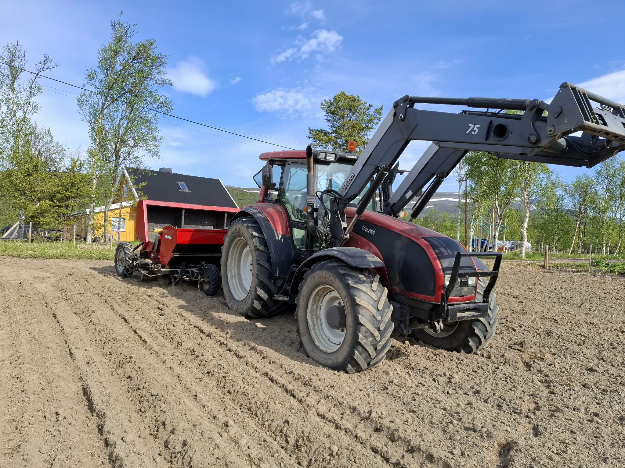 Traktor hypper opp potetradene i åkeren på Bonakas
